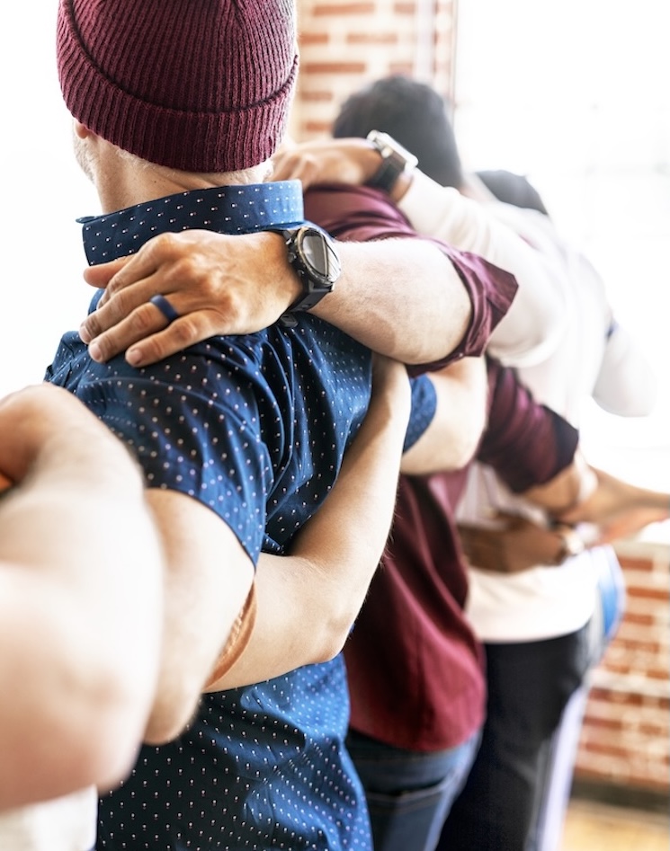 Group of men supporting one another.