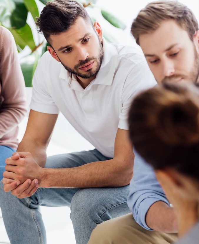 selective focus of men sitting during group therapy session