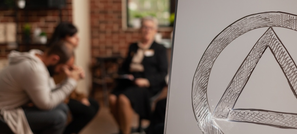 Close up of aa therapy meeting symbol on white board. 