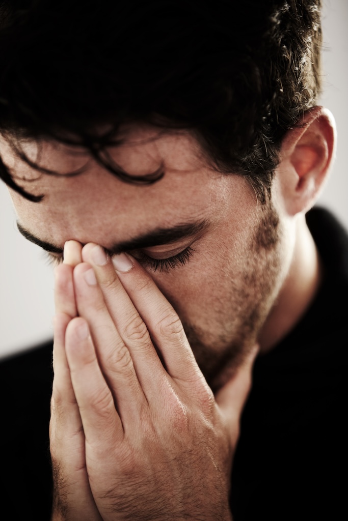 Young man with his head in his hands.