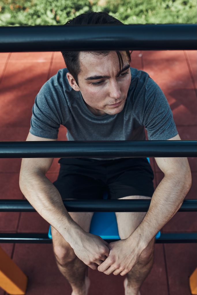 Portrait of depressed young man taking a break during his workout