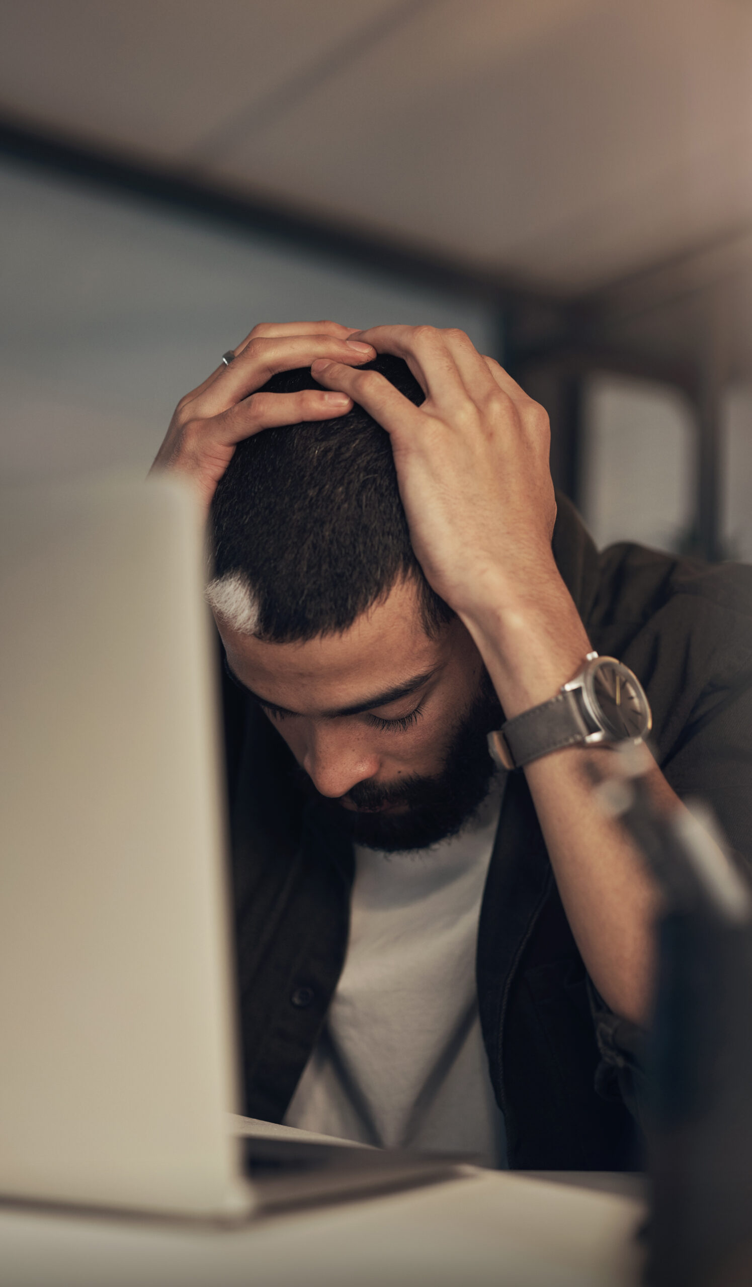 Man with head in hands, distressed due to opioid addiction.